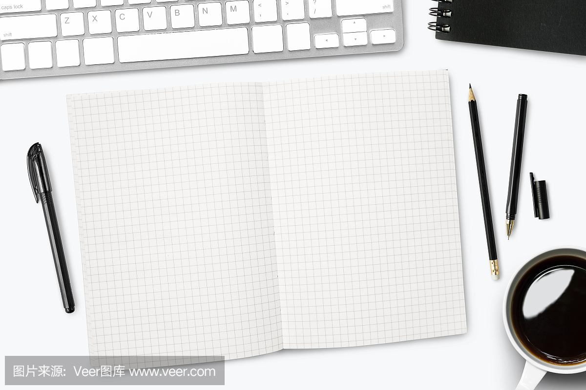 白色的桌子上的空白网格线笔记本页面。顶视图