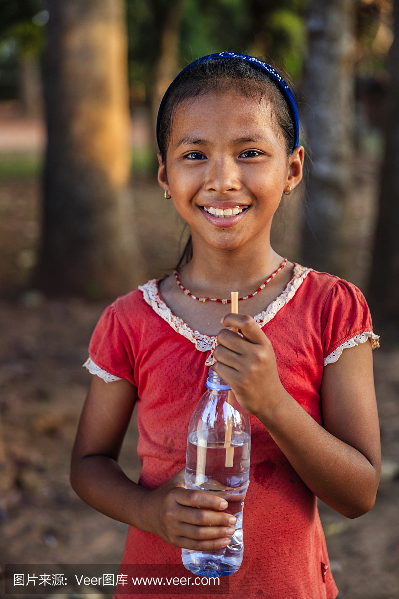 喝新鲜的水,柬埔寨的愉快的柬埔寨女孩画象