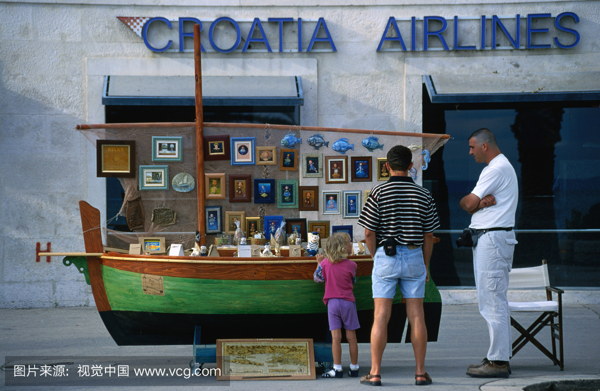 站在克罗地亚航空公司办公室外面的船形纪念品