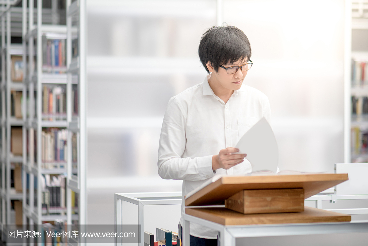 年轻的亚洲人大学生阅读推荐书在图书馆登上领