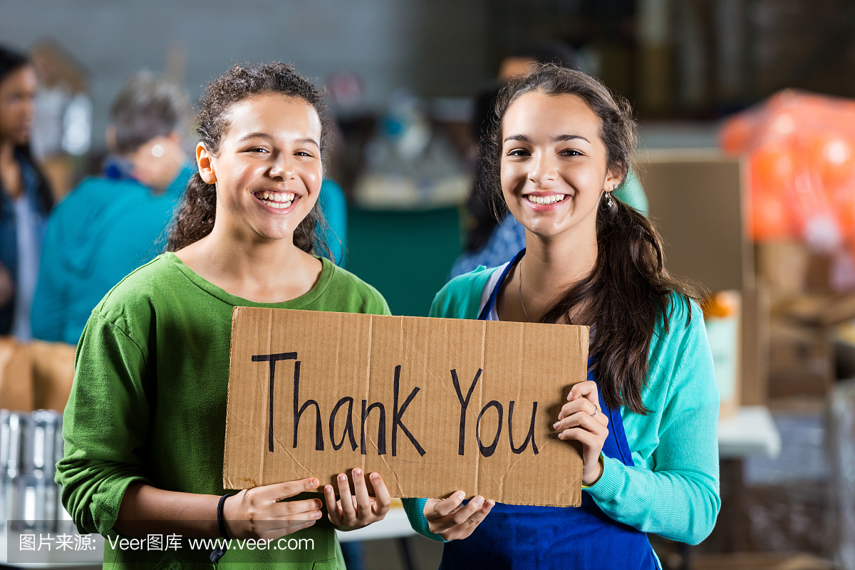 十几岁的女孩在食物银行举行谢谢你登录