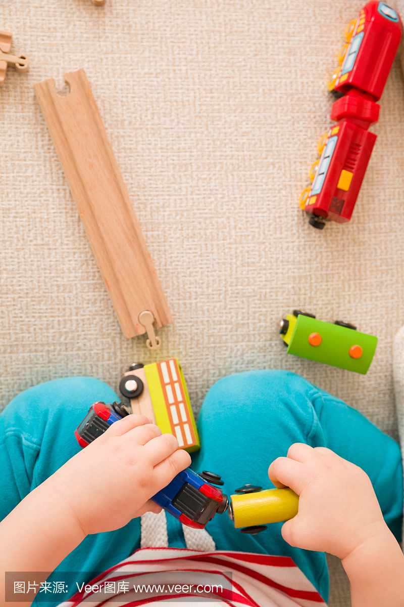 孩子的手的特写镜头玩木制火车玩具和铁路。顶