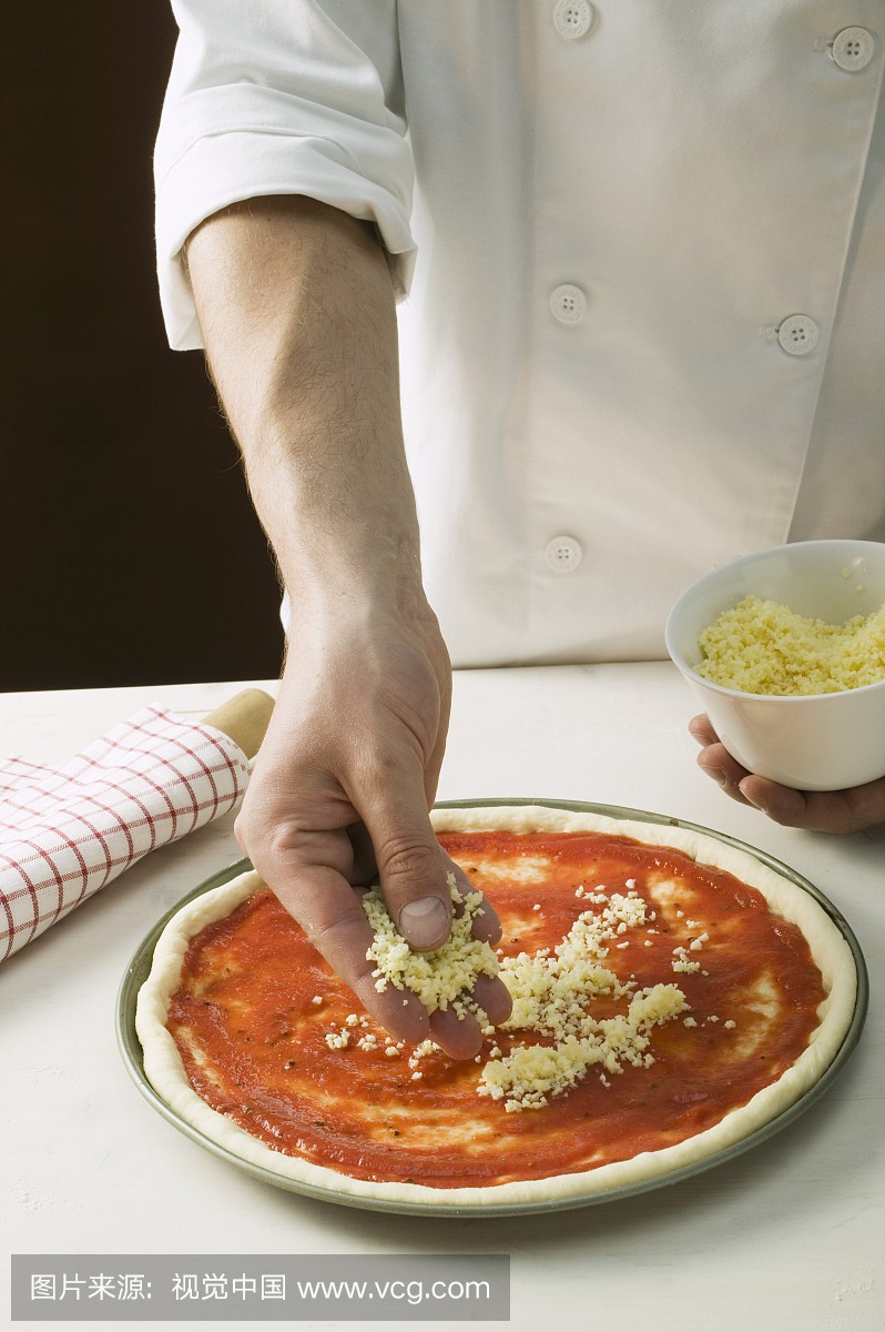 Sprinkling pizza with cheese