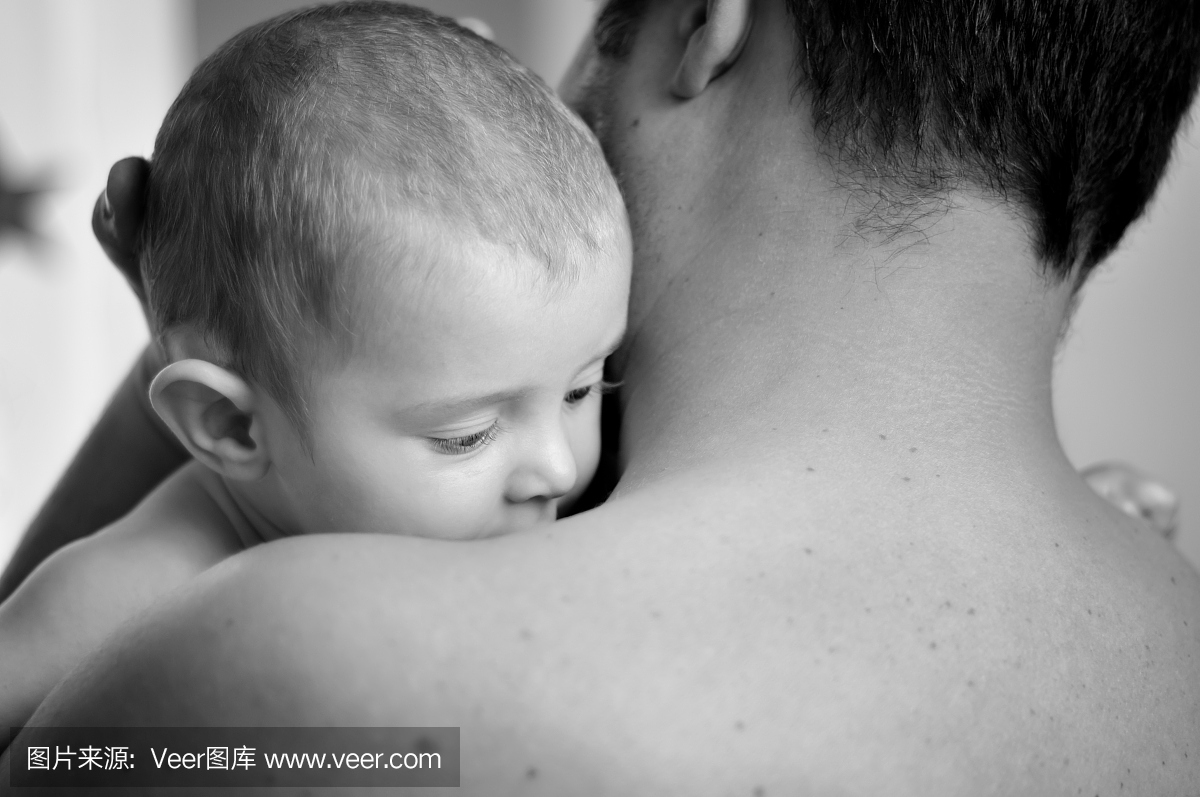 父亲拥抱他的孩子在黑色和白色