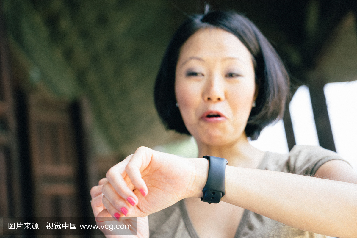 日本快乐的女人在户外使用智能手表