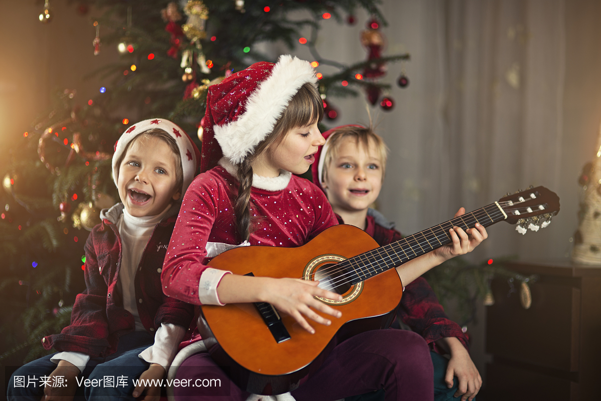 孩子们在圣诞树附近唱歌颂歌