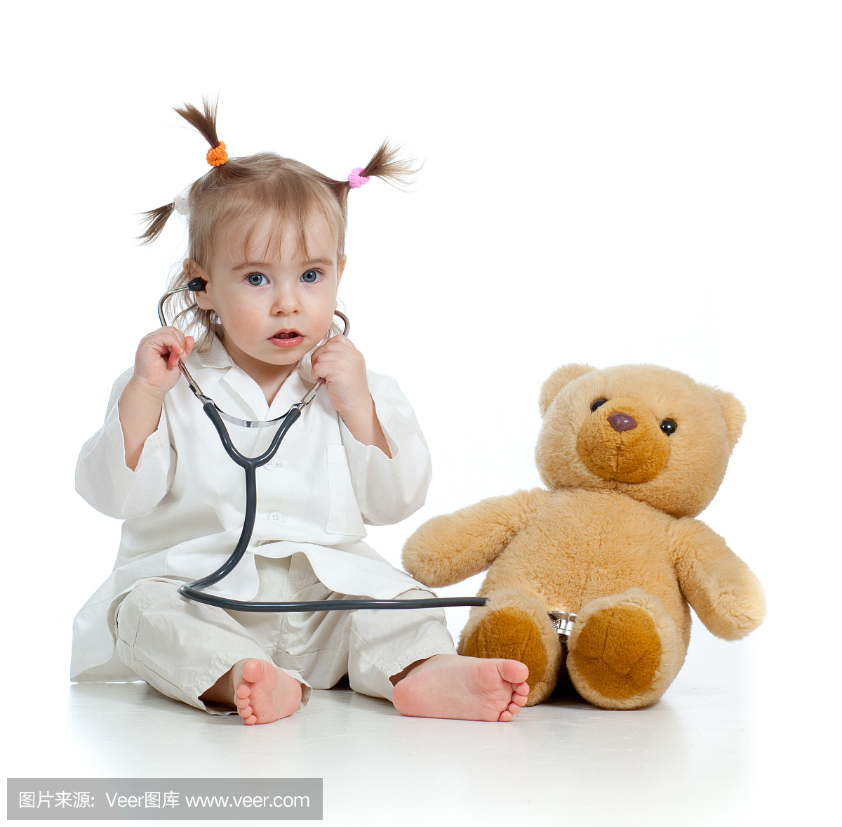 可爱的小孩女孩与医生和玩具玩具的衣服