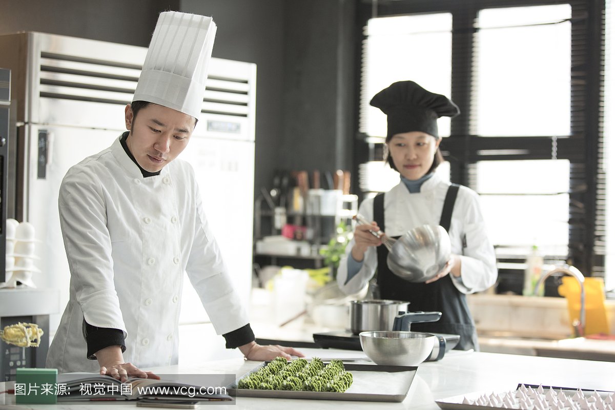 男、女厨师在厨房专研学习制作甜点心
