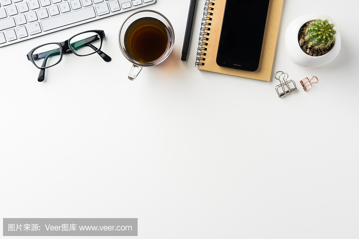 白色桌面背景的顶视图与笔记本,咖啡,智能手机