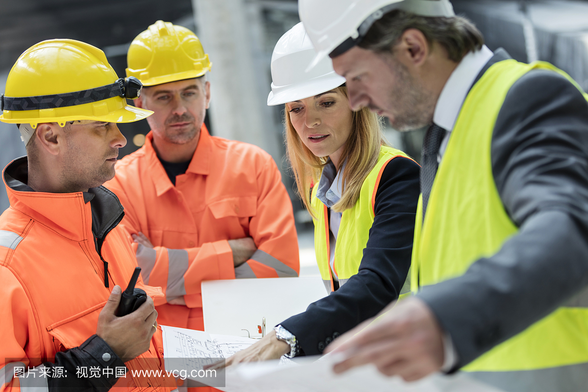 Engineers and construction workers reviewing