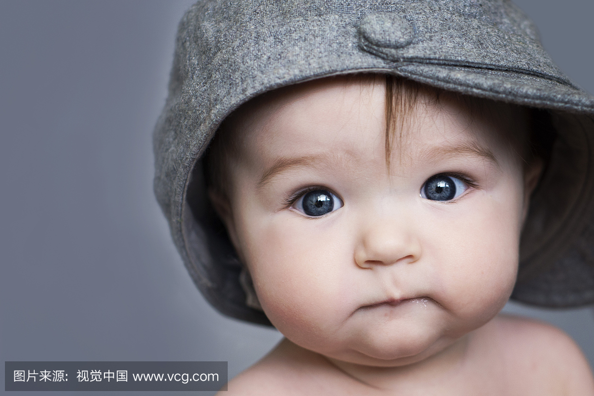 美丽的蓝眼睛宝宝在空白灰色的背景\/帽子