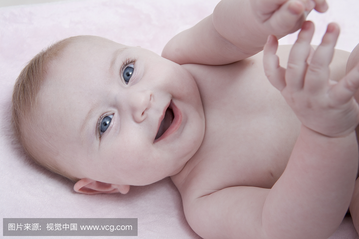 婴儿用粉红色毯子上的明亮的蓝色眼睛
