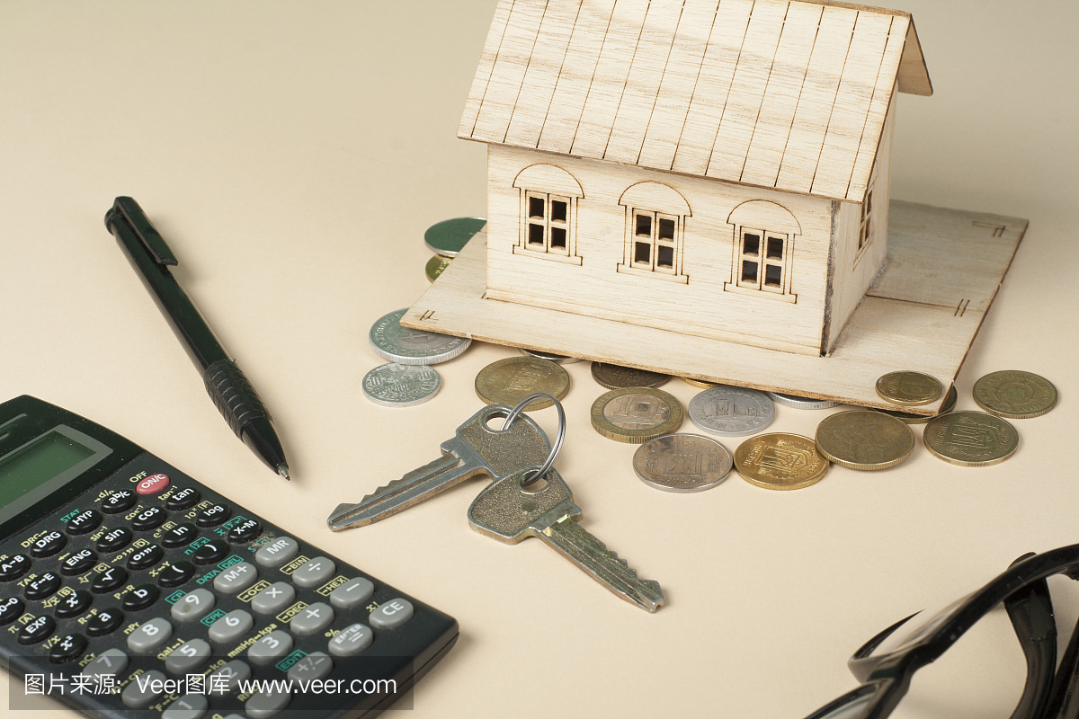 家庭储蓄,预算概念。房子,笔,计算器和木制办公
