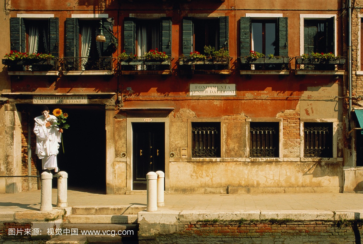 意大利,威尼斯,皮埃罗拿着向日葵,站在运河