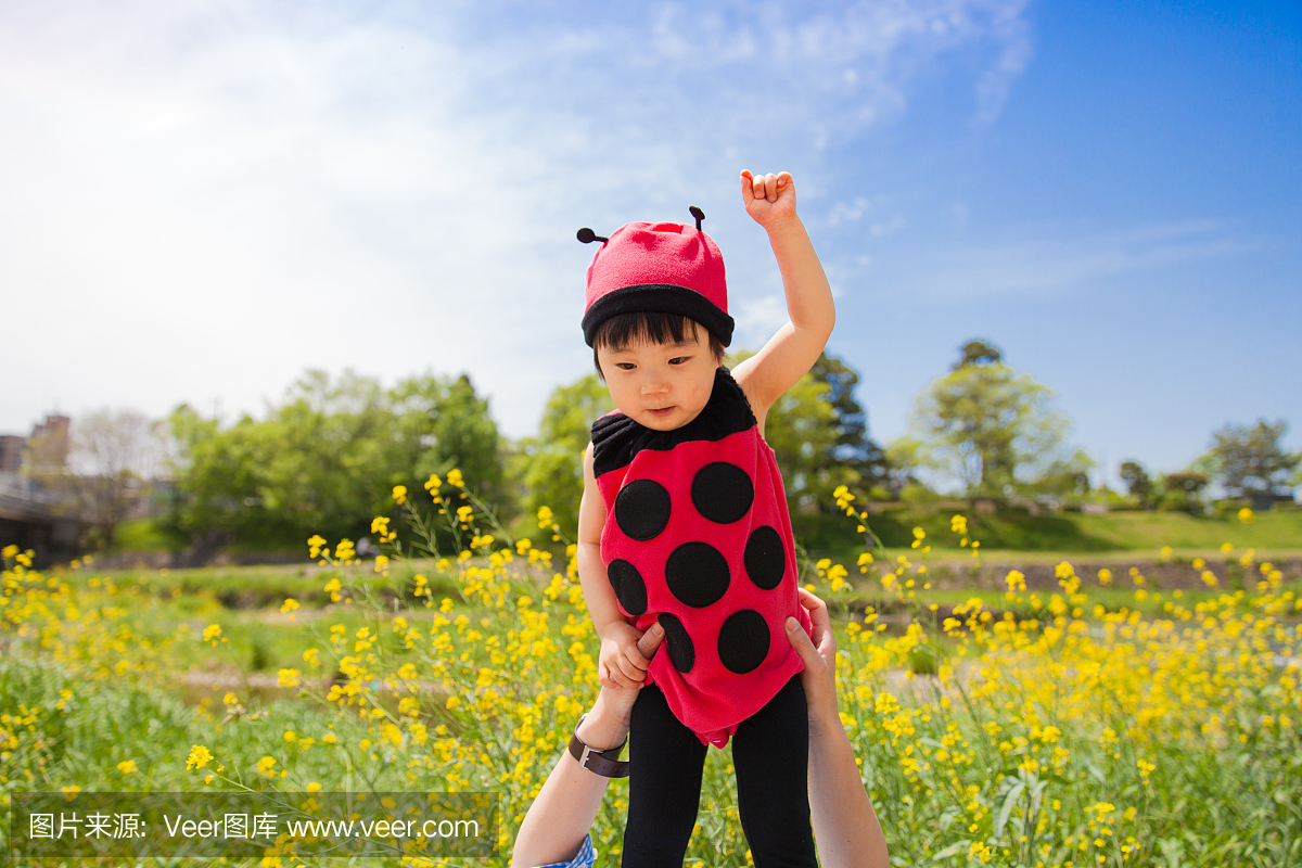 在瓢虫衣服上飞过花园的日本女婴