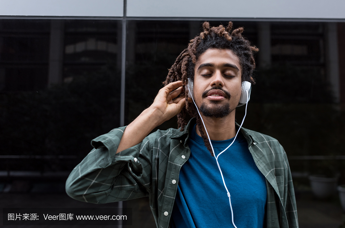 一个黑人听音乐的耳机和眼睛的肖像关闭享受音