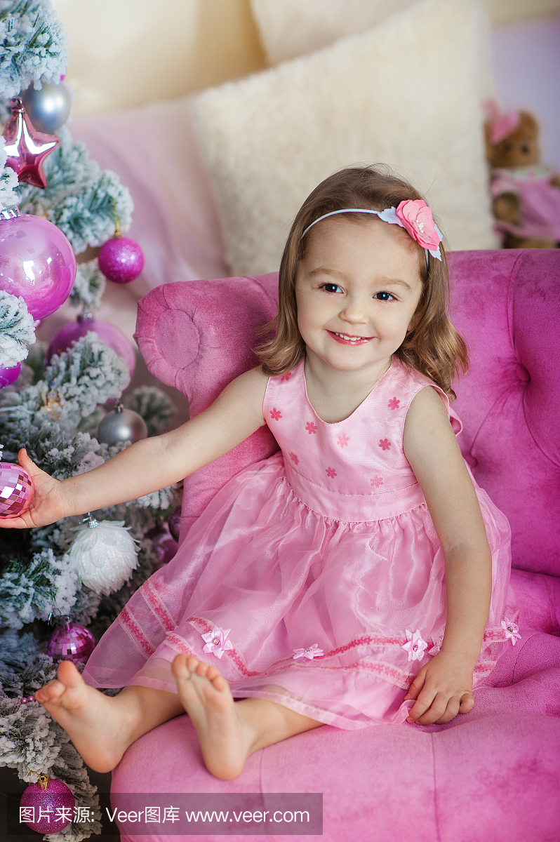 快乐快乐的小女孩在圣诞前夕兴奋,坐在下面