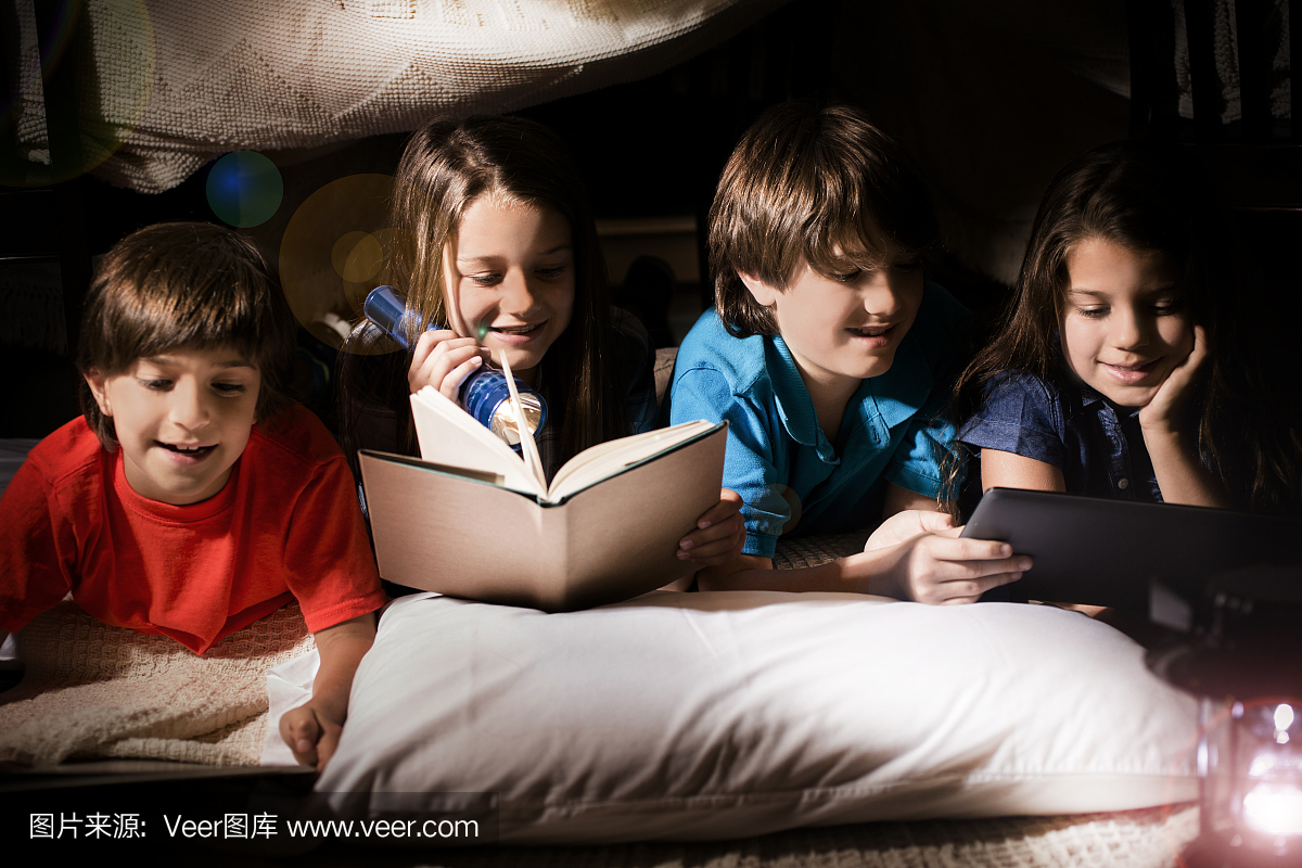 一群孩子在家里用自制的帐篷一起阅读。