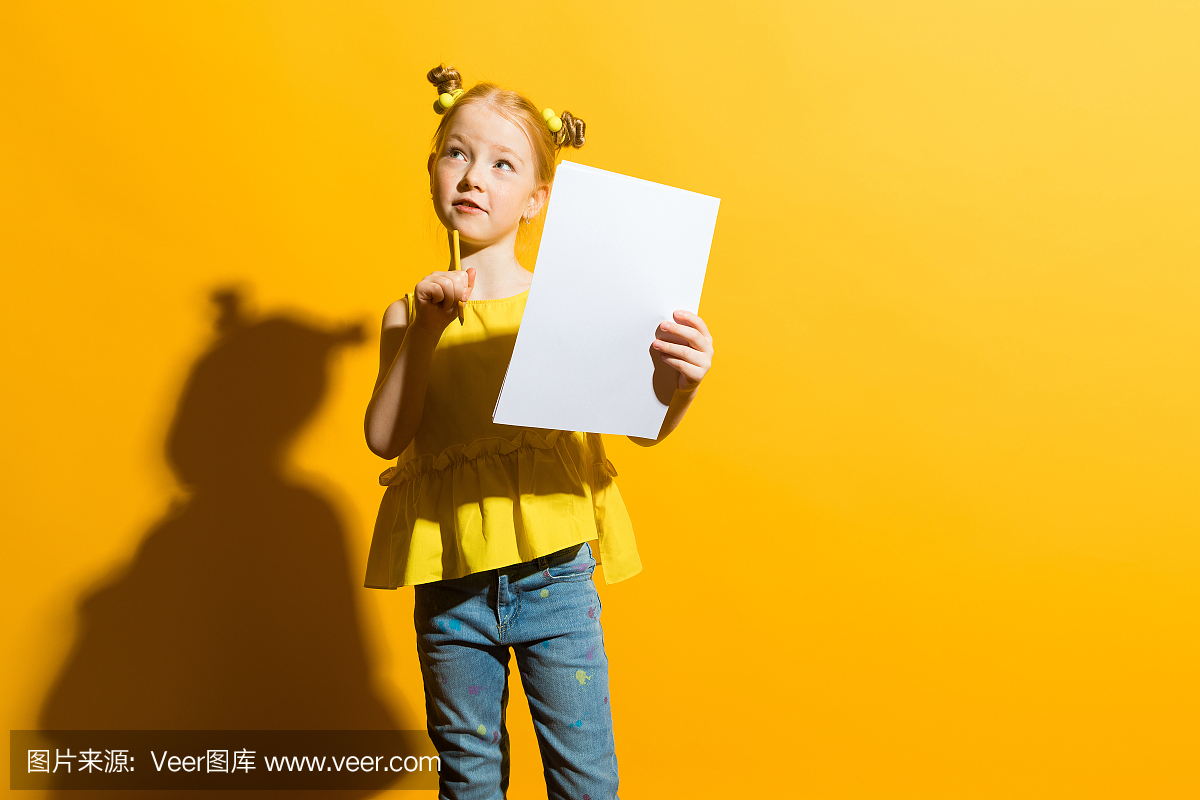 红头发在黄色背景上的女孩。一个漂亮的女孩手