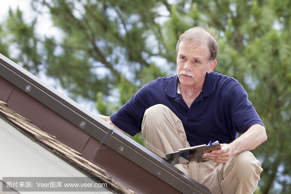 屋顶检查员在陡峭的屋顶上检查住宅天窗。