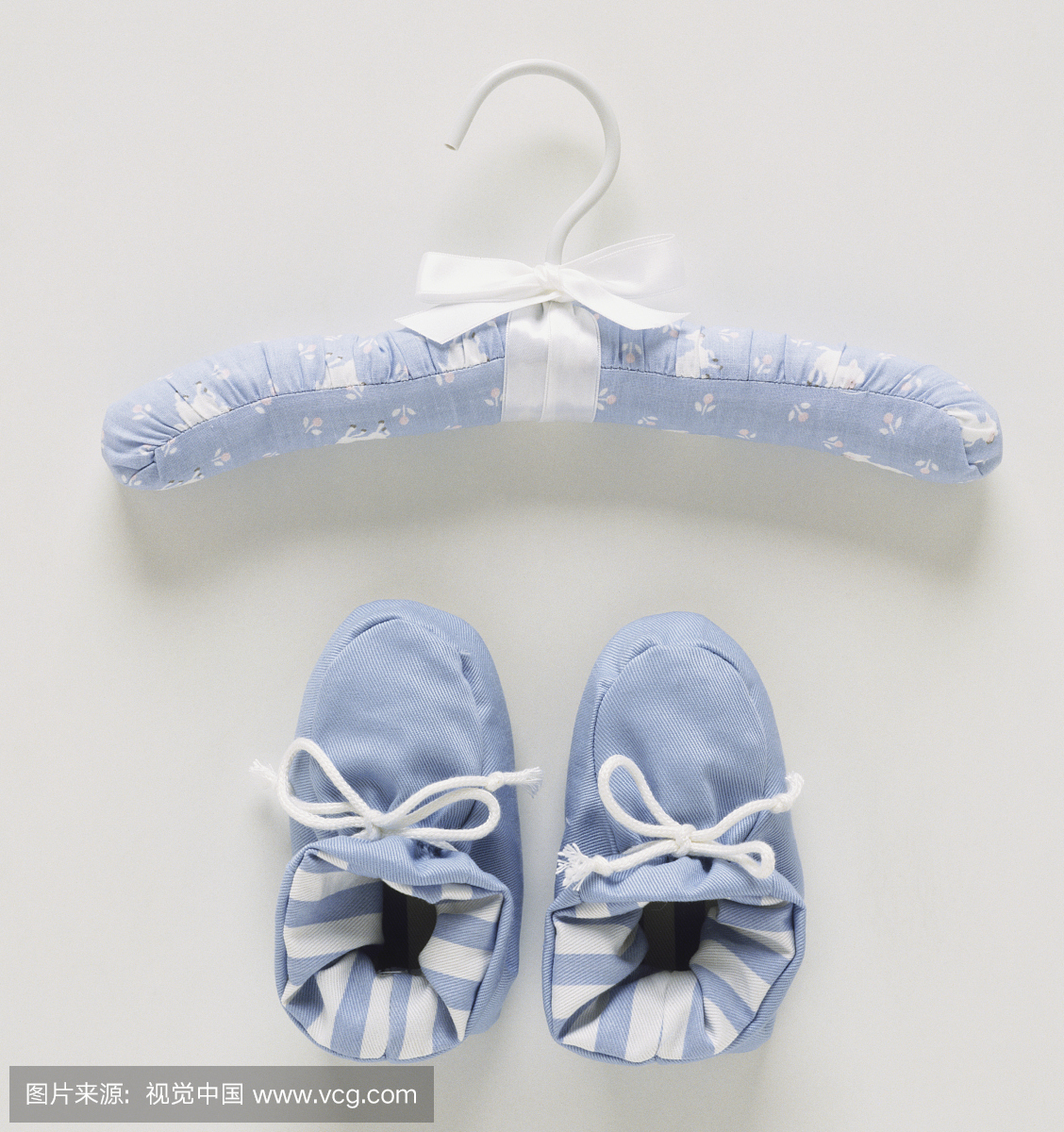 蓝色和白色的衣架和一双婴儿鞋