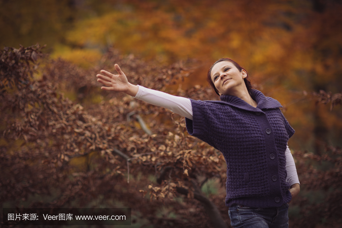 快乐的秋日女人在森林里
