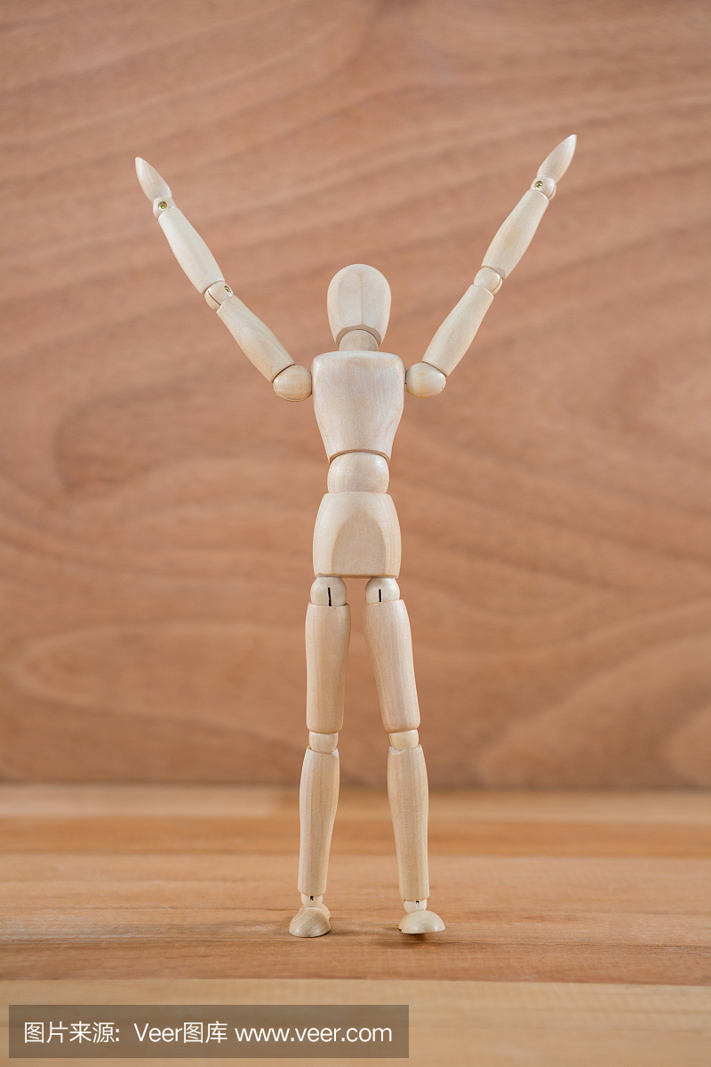 用手举起的木制小雕像站立