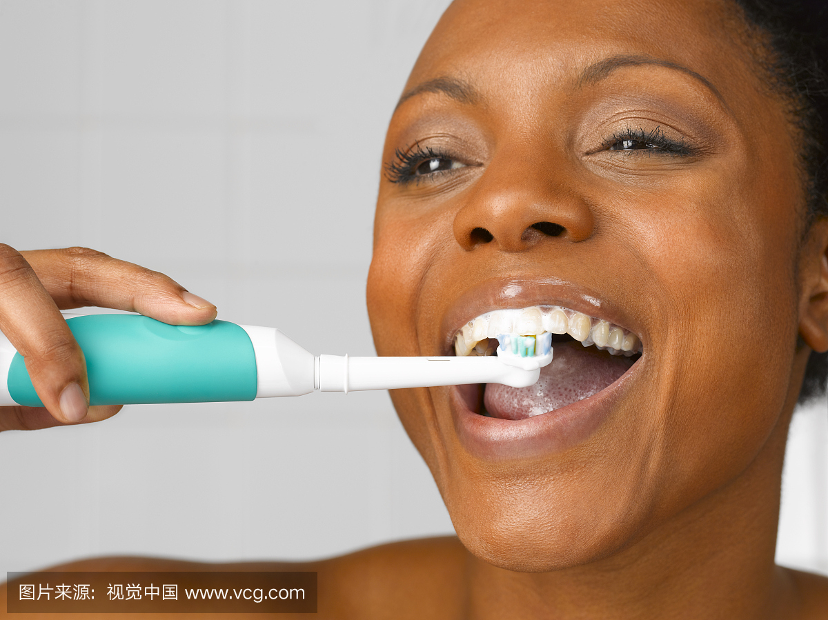 女人用电动牙刷清洁牙齿,关闭,工作室拍摄