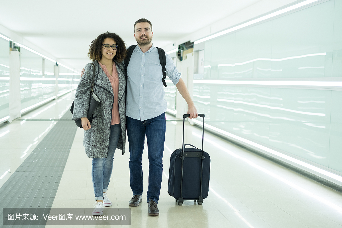 年轻夫妇与一个行李箱准备旅行