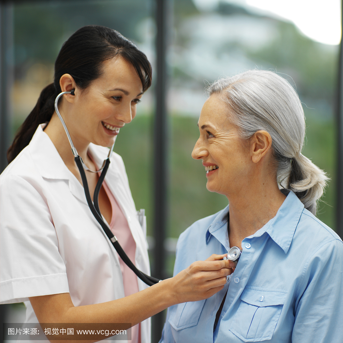 用听诊器检查成年患者胸部的年轻医生的特写镜头
