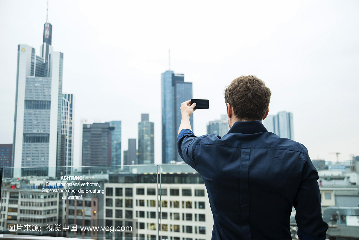 德国黑森州法兰克福,年轻人用他的智能手机拍