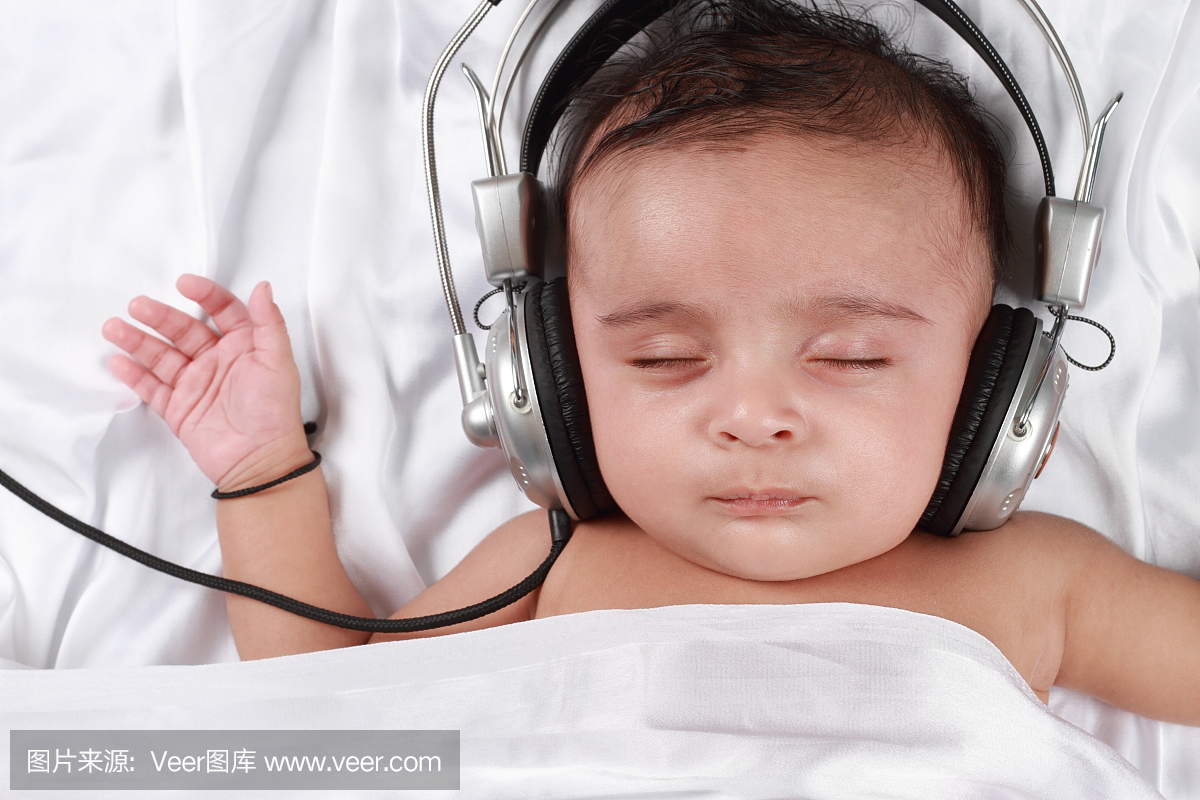 两个月大的婴儿用耳机听音乐