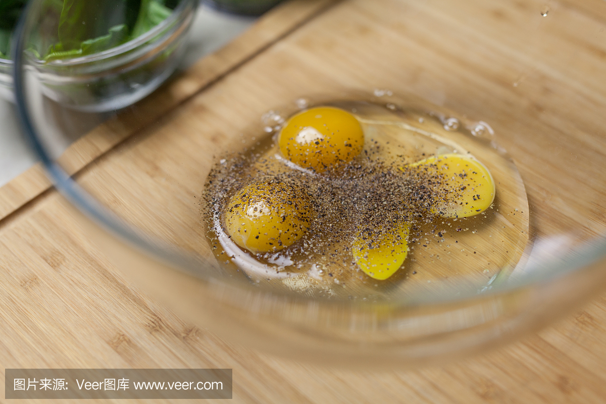 粉碎的黑胡椒在生鸡蛋碗里