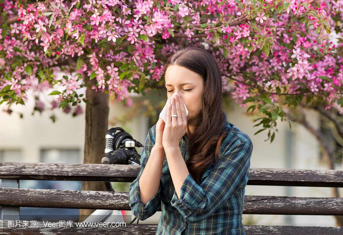 女人吹鼻子,因为花粉过敏