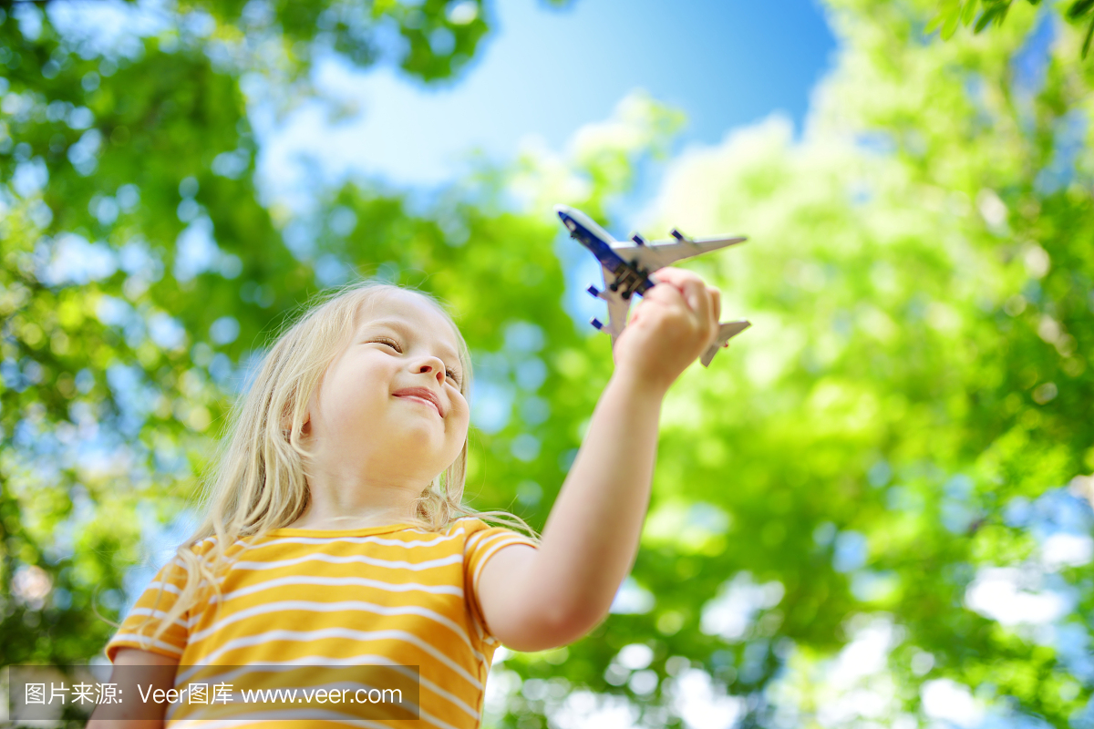 可玩的小女孩玩户外的小玩具飞机