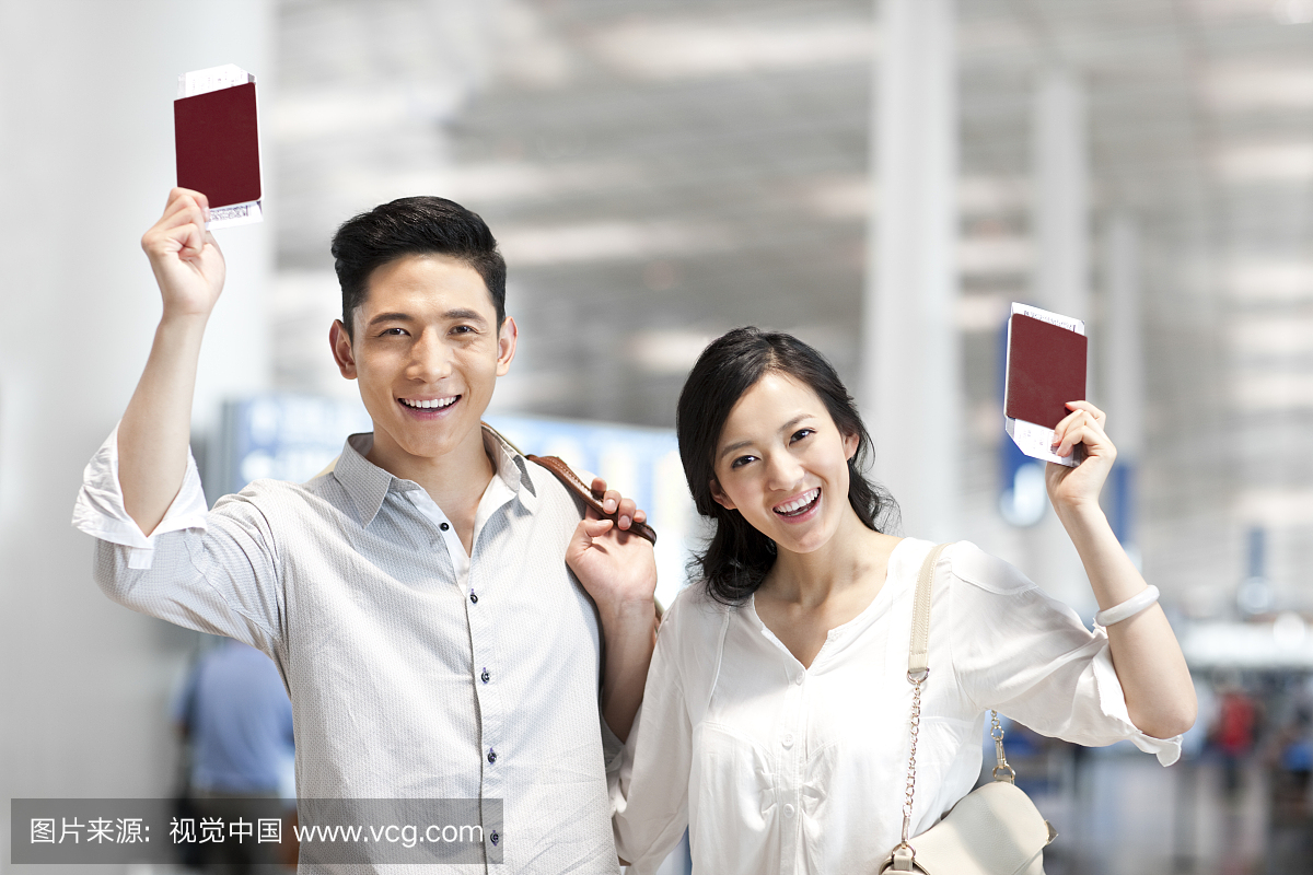 年轻情侣拿着机票和护照