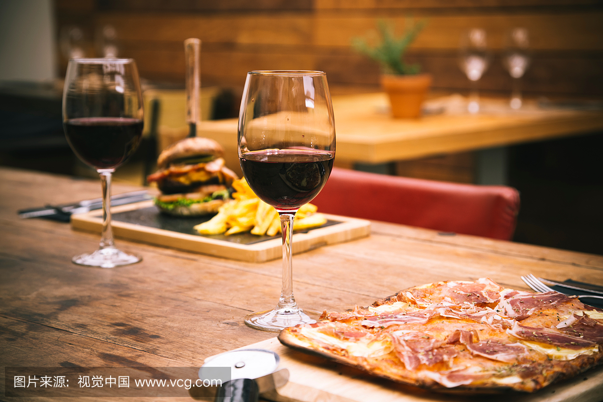 红葡萄酒用在木桌上供食的薄饼在餐馆