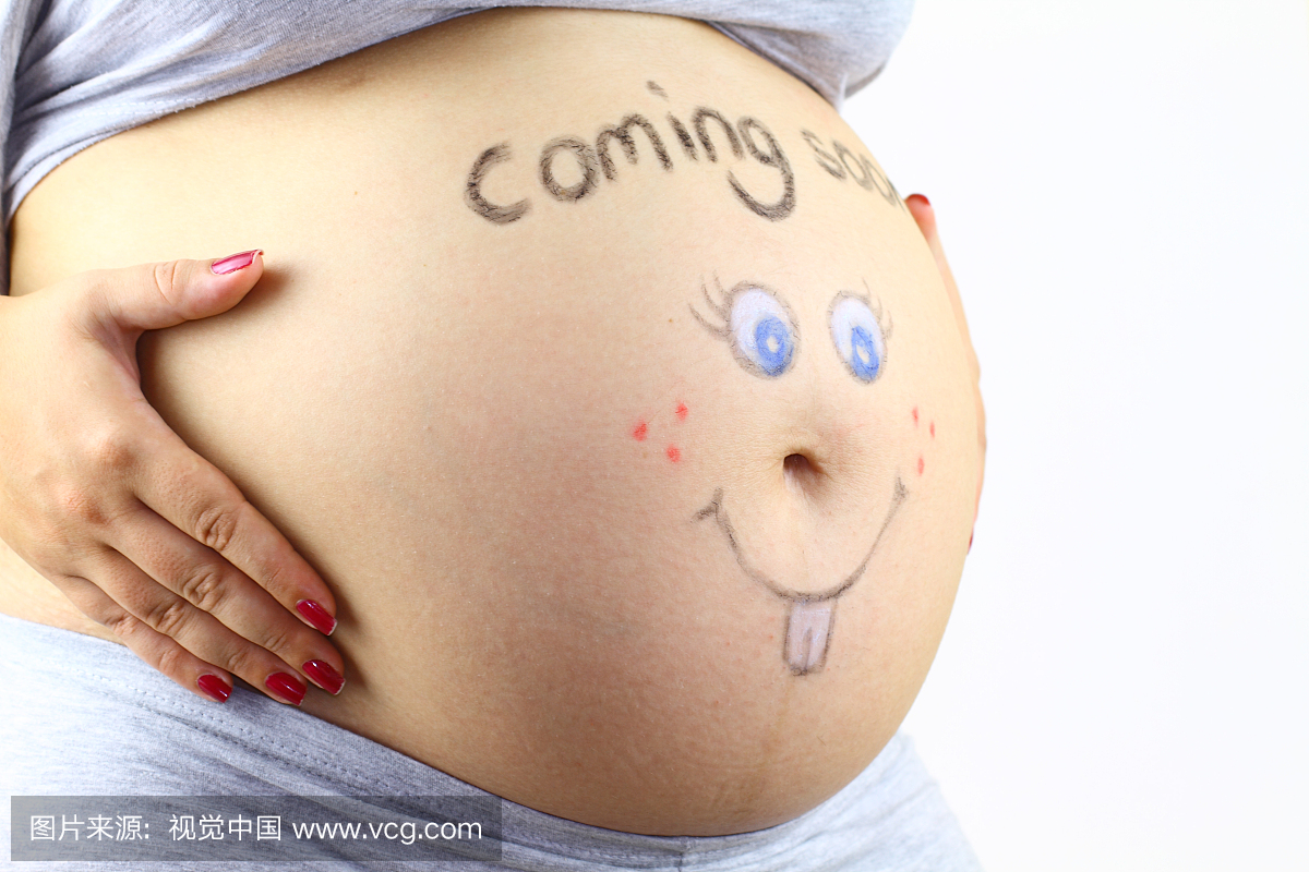 怀孕的肚子与手绘的笑脸和标志