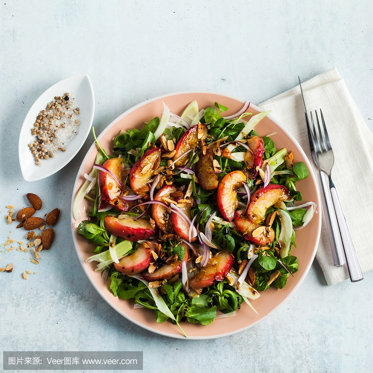 summer, very tasty salad with peaches, sweet onions and arugula with almonds on a table in a plate. simple healthy recipe
