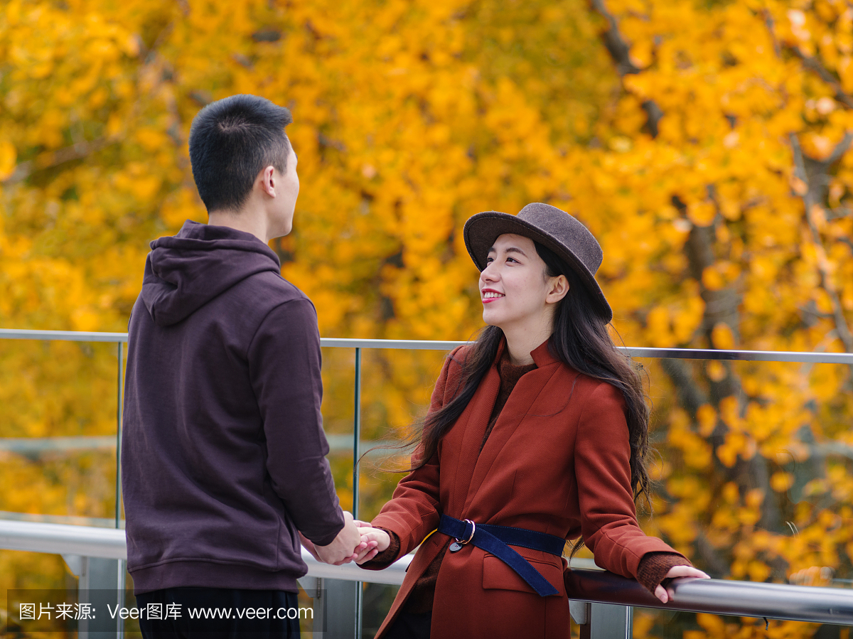 中国年轻的男人和女人手牵着手,站在一起与情