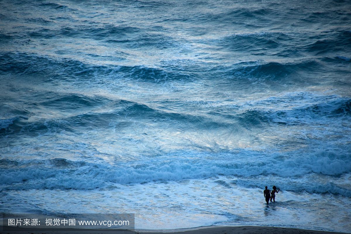 一些夫妇在海洋波澜壮阔的海滨海滨。