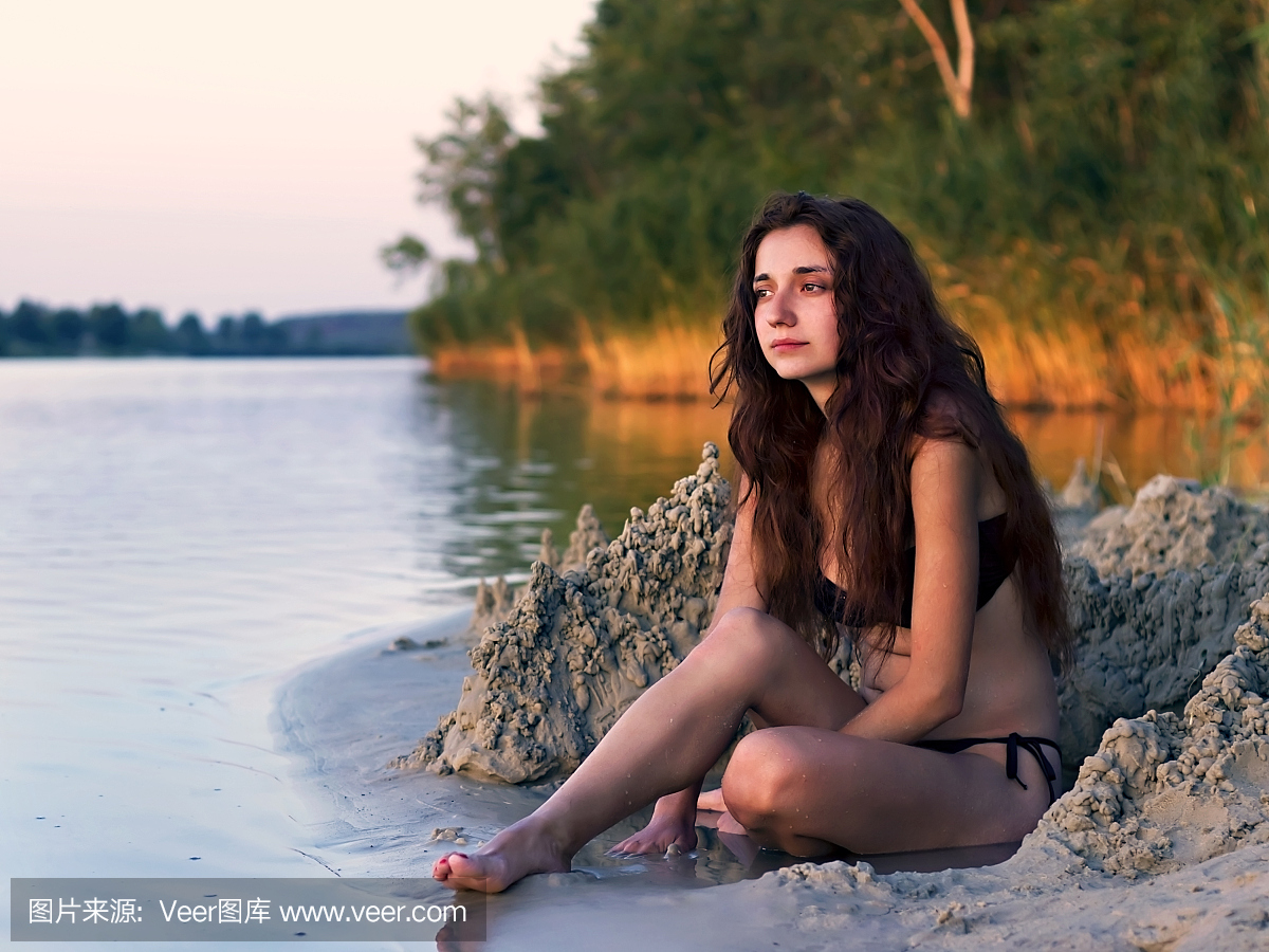 坐在湖边的年轻女孩