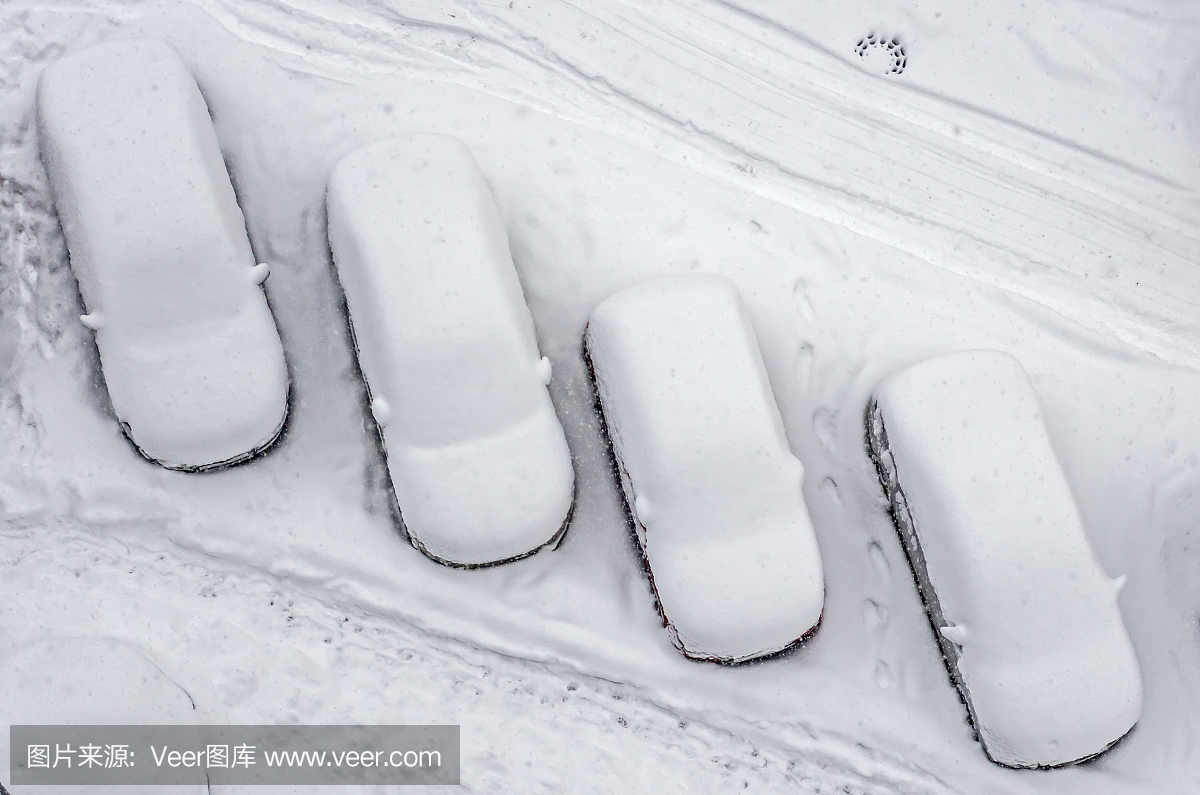 积雪覆盖的车在停车场。城市场景。暴风雪过后