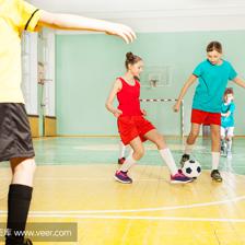 儿童训练足球在学校体育馆
