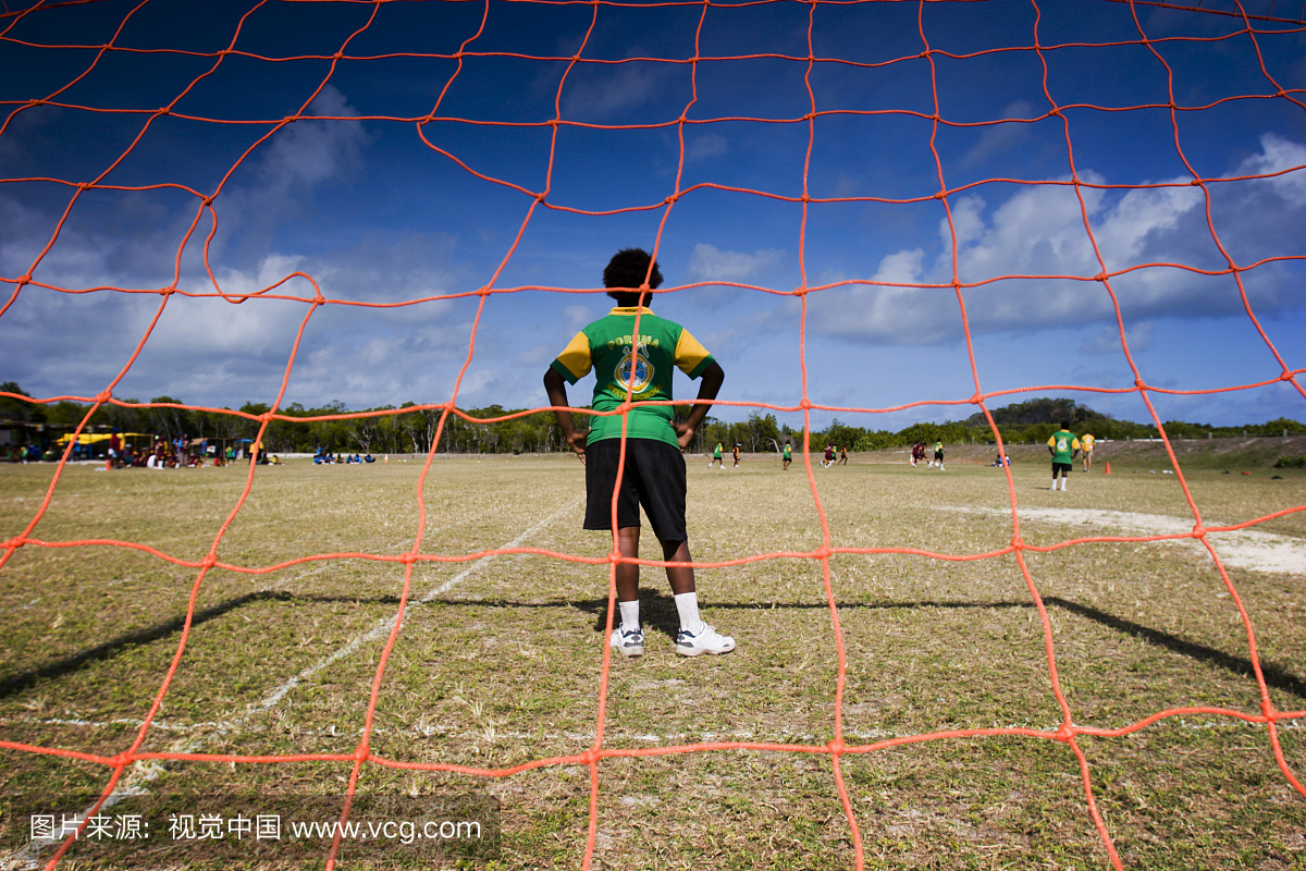 托雷斯海峡岛民男孩站在足球比赛中的目标。
