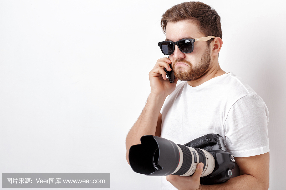白色衬衫上的年轻专业摄影师持有数码相机