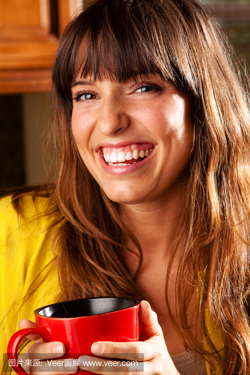 微笑与咖啡杯美丽的女人