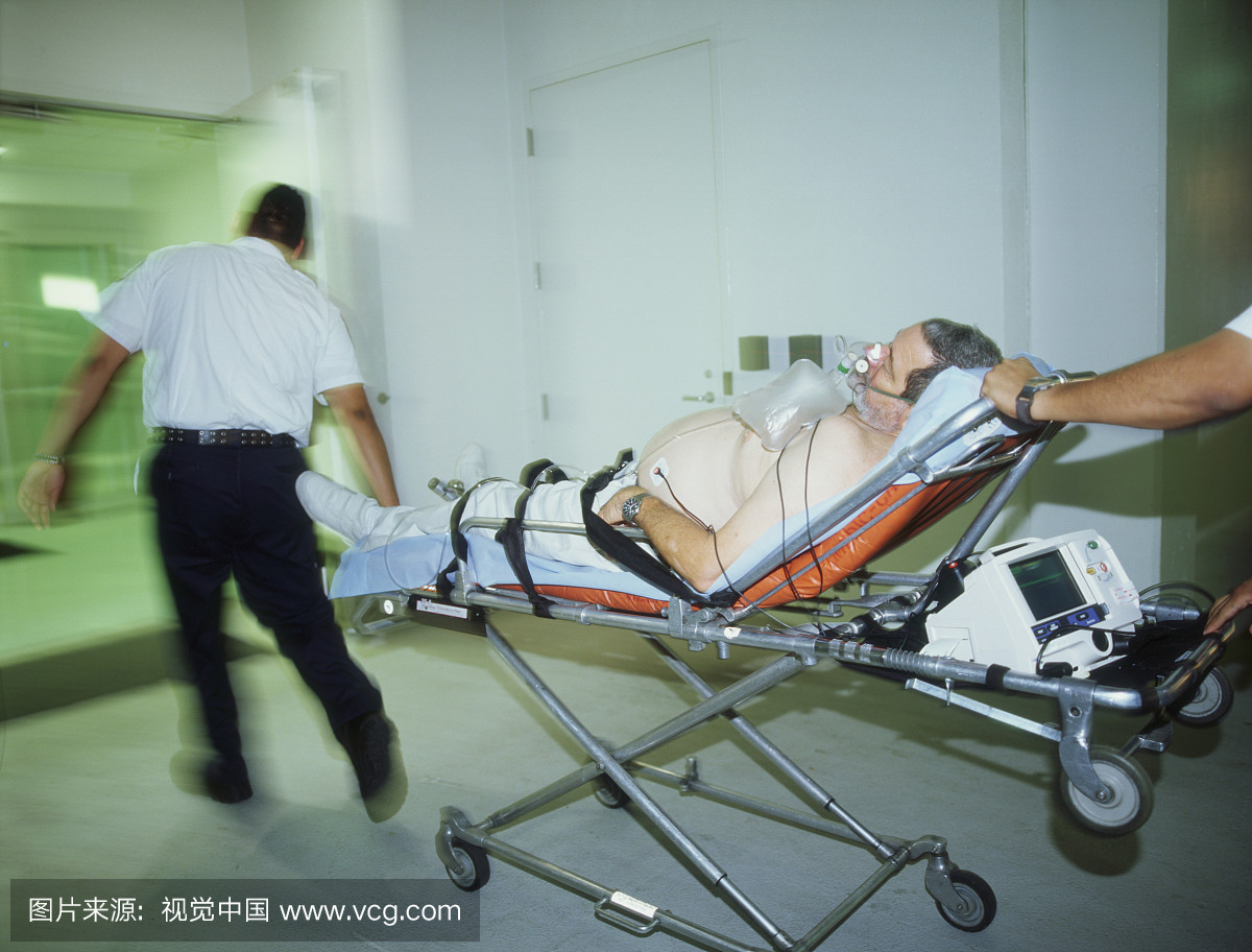 男病人被两名男子在医院的床上轮转
