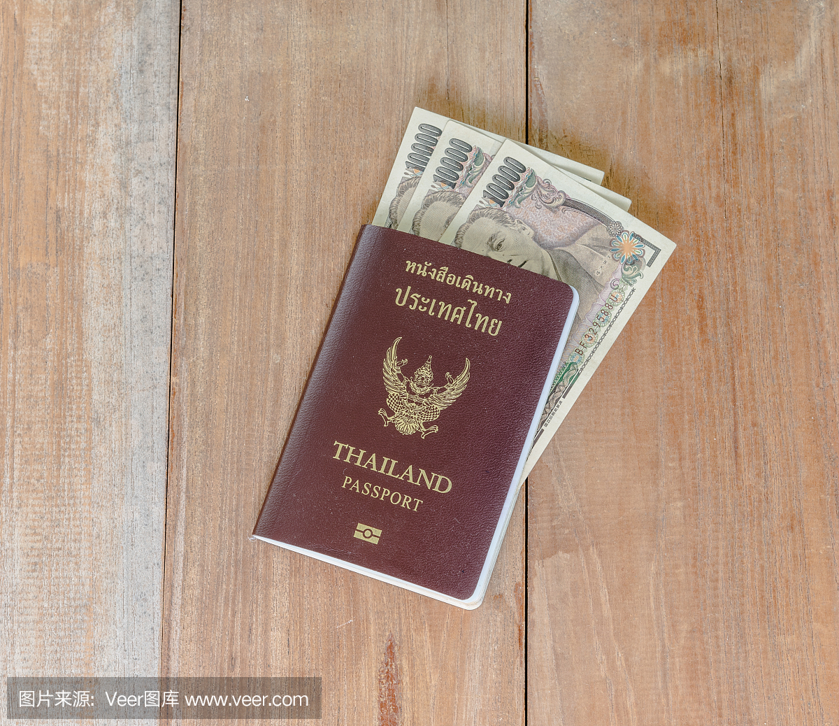日本钱插入泰国护照放在木地板上