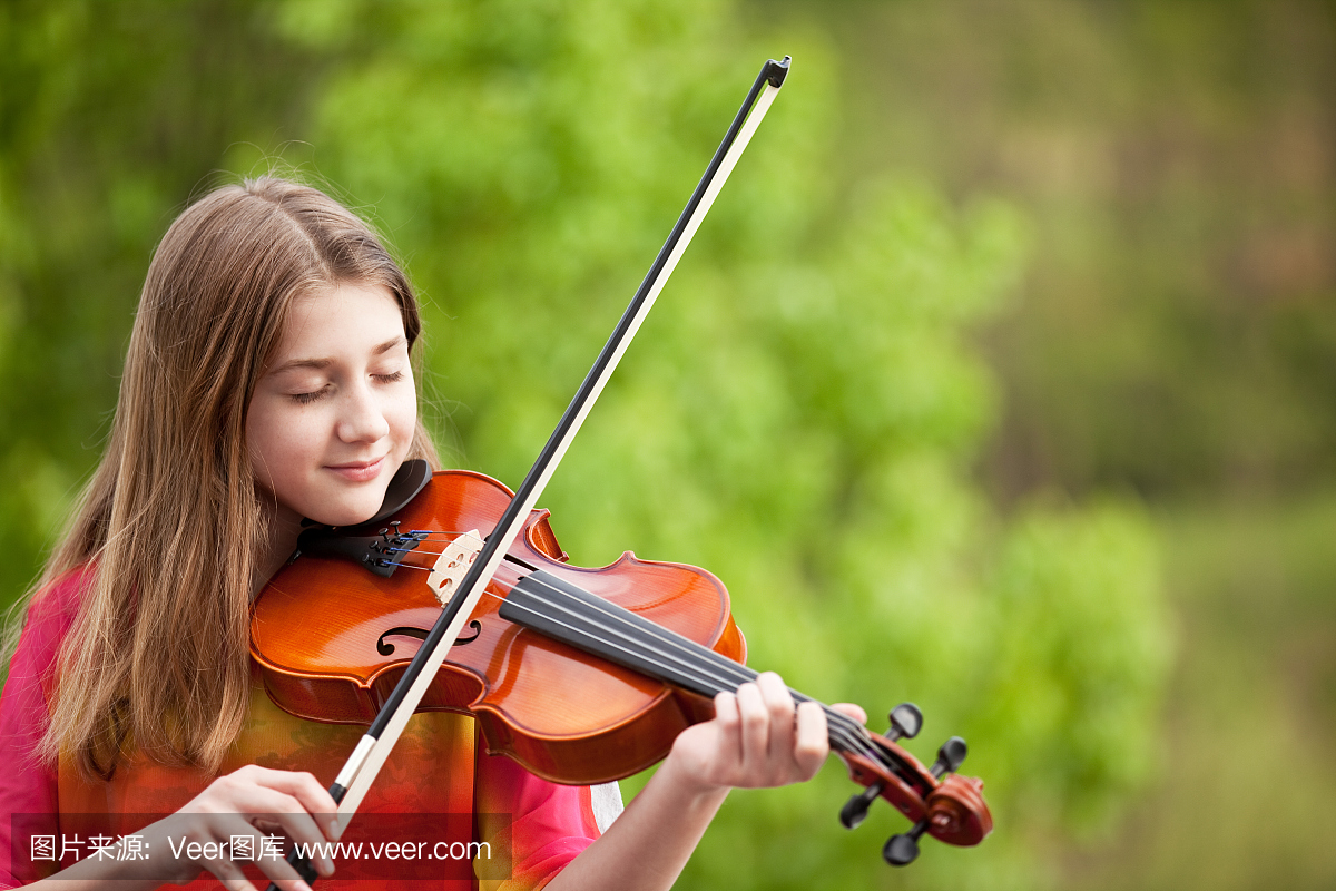 美丽的年轻女孩在户外使用中提琴